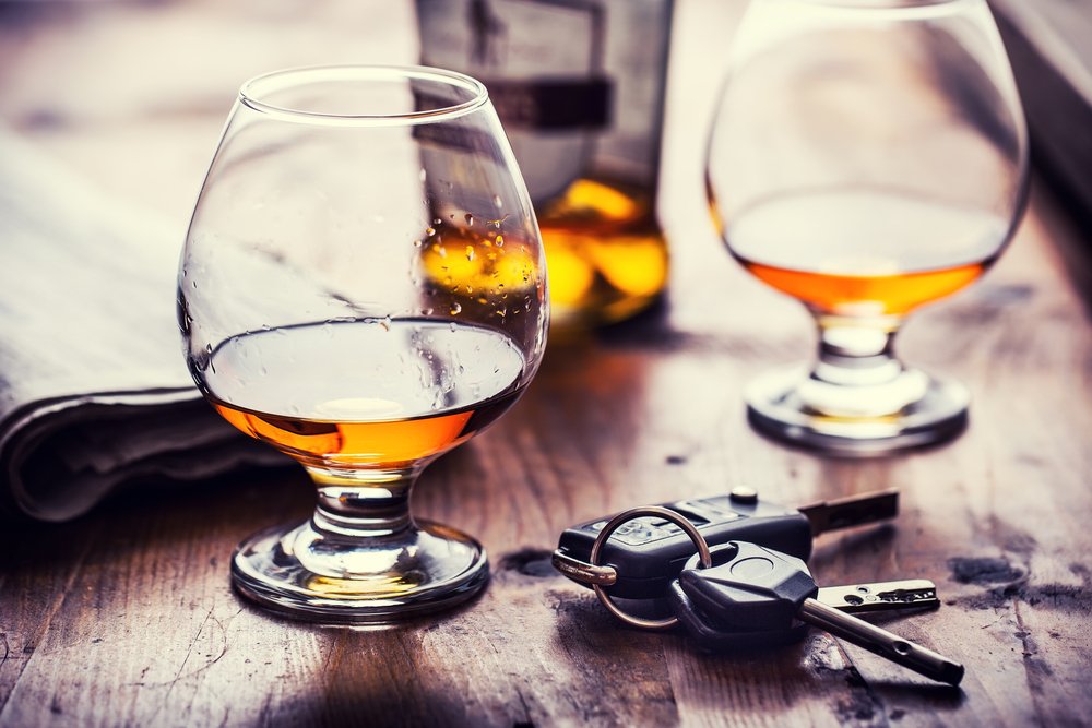 Llaves de coche colocadas junto a dos bebidas alcohólicas.