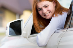 A young woman shocked as she is involved in an accident as she pulls out of her parking spot.