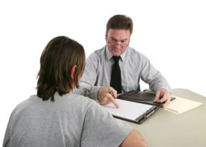 A parole officer speaking with a parolee regarding his parole violation.