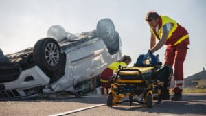 Escena de un gran accidente de automóvil con paramédicos sacando una camilla.