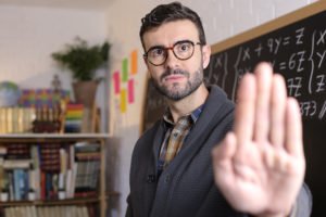Maestro sosteniendo la mano para defenderse de un asalto