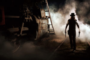 Man with gun next to train