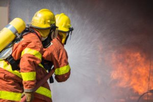 Firefighters fighting back a fire, which might potentially lead to a person being injured, resulting in an aggravated arson charge.
