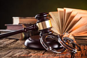 Legal books next to a gavel and handcuffs, representing the legal concepts of probation and parole.
