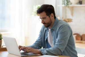 Man at laptop applying for DMV hearing