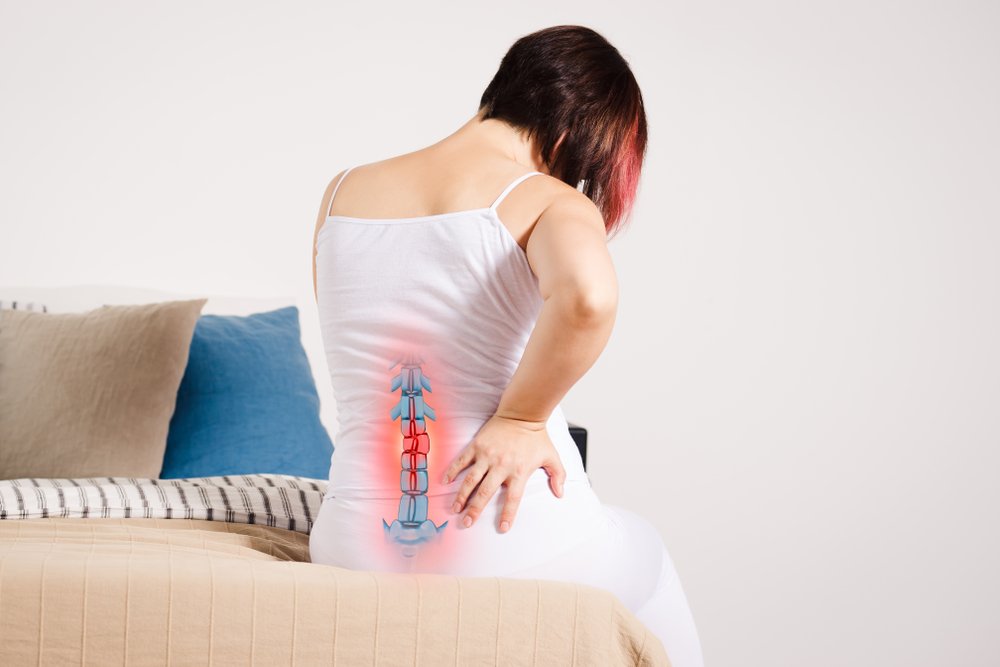 A woman experiencing back pain due to degenerative disc disease.