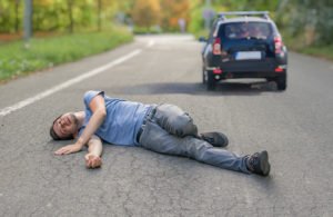 Peatón en la carretera después de una colisión con el coche que se aleja a toda velocidad