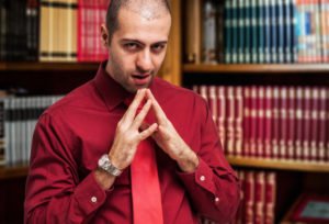 Sinister looking non-lawyer in front of bookshelf with legal books