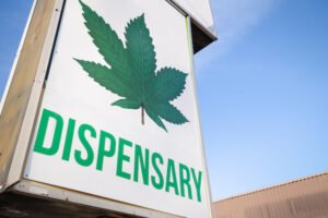 A cannabis dispensary sign with a large marijuana leaf on it.