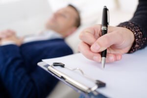 Closeup of psychologist's clipboard with patient in background