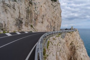 Guardrail on a cliff with water in background