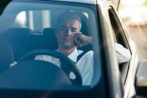 Conductor triste detrás del volante de un coche