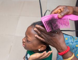 Young African-American girl getting her hair combed