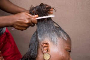 African-American woman getting her hair combed at a salon