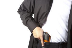Man taking out gun hidden in waist of jeans