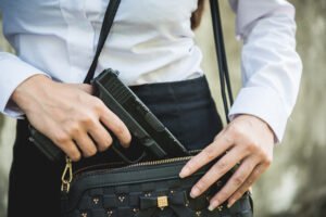 Woman taking out gun from purse