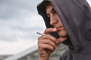 teenager smoking a joint outside