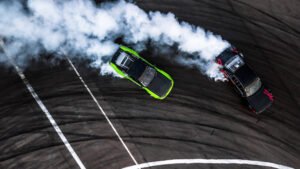 Birds-eye view of two race cars turning on a curve