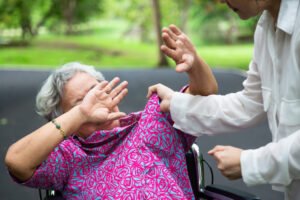 Man punching elderly woman in chair