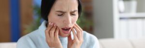 Woman Suboxone victim holding her jaw while experiencing a toothache