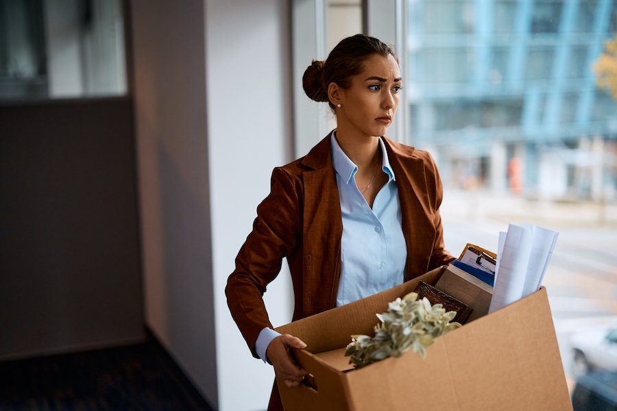 Fired worker holding box of office belongings