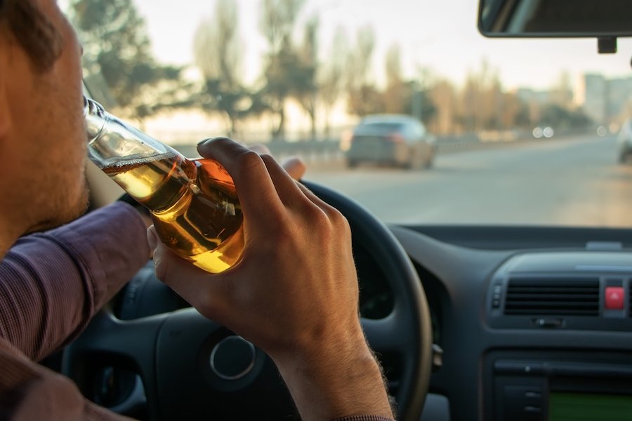 Man drinking beer while driving