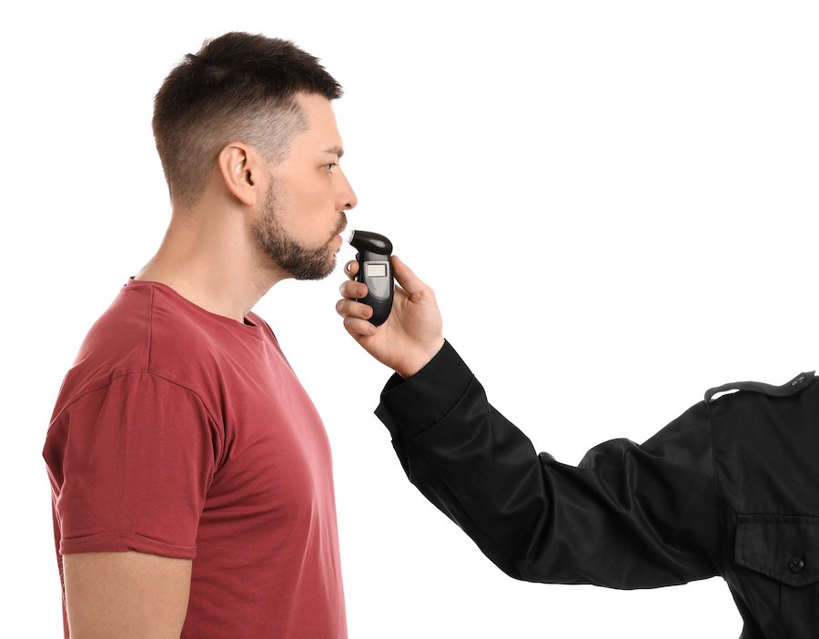 Man breathing into a breathalyzer 