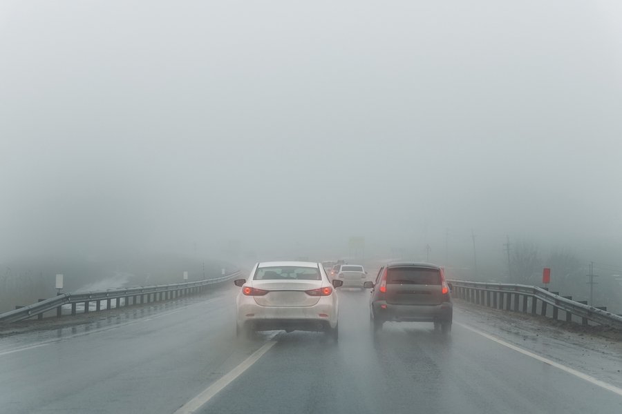 Sedán adelantando a otro sedán en un día lluvioso