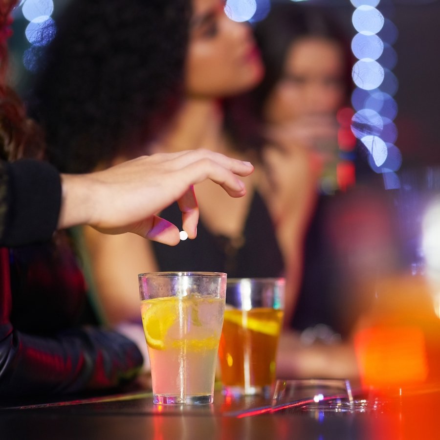 Hand drugging drink at club