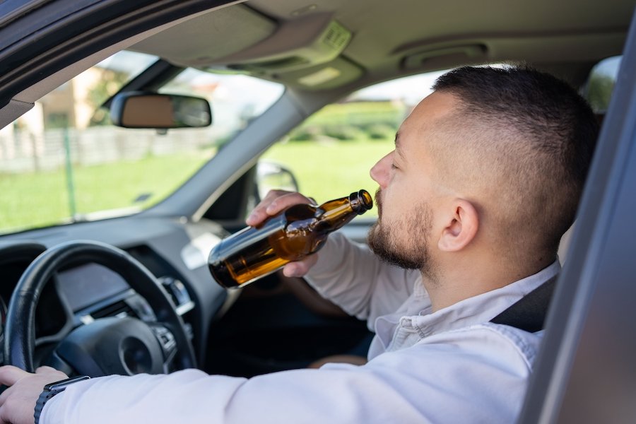 Driver drinking beer in driver's seat